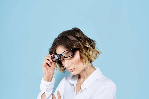 Geschäftsfrau auf blauem Hintergrund Brille mit dunklem Rand lockiges Haar Helles Hemd abgeschnittene Ansicht — Stockfoto