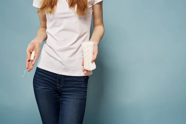Mädchen mit Tampon und Kissen in den Händen auf blauem Hintergrund Hygiene Sauberkeit Menstruation — Stockfoto