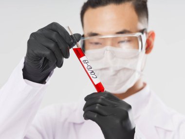Bilim adamı koruyucu maskeler. Kan testi tüpü ile test tüpü.