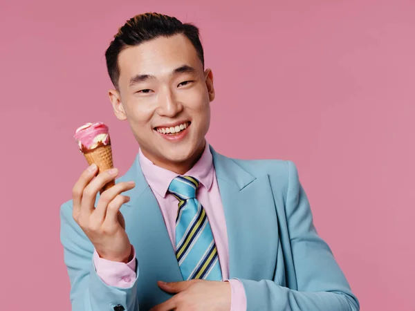 アジア系の陽気な男が喜びを手にアイスクリップビューのピンクの背景 — ストック写真