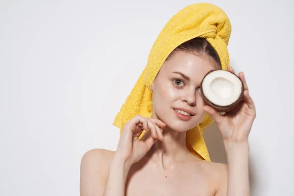 Bella donna con asciugamano giallo sulla testa che tiene le mani di cocco esotico pulito spa pelle — Foto Stock