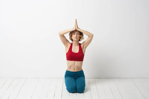 Kot pantolonlu bir kadın, açık arka plan ve jimnastikte ince bir figür üzerinde yoga yapıyor. — Stok fotoğraf