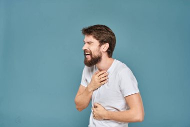 Beyaz tişörtlü, el kol hareketleri yapan, stüdyosu kesilmiş biri.