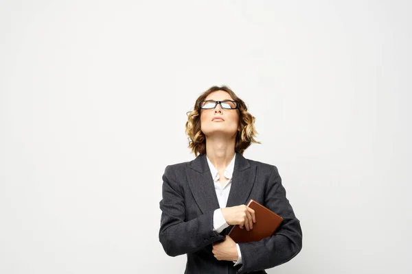 Donna d'affari con blocco note e occhiali lavoro luce sfondo ritagliato vista del modello tuta. — Foto Stock