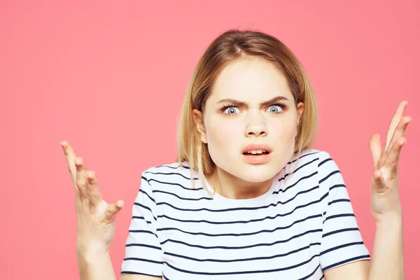 Blonde gestreifte T-Shirt Emotion Geste Hände unzufrieden Gesichtsausdruck rosa Hintergrund — Stockfoto