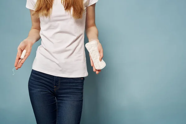 Chica con un tampón y una almohadilla en sus manos sobre un fondo azul higiene limpieza menstruación —  Fotos de Stock