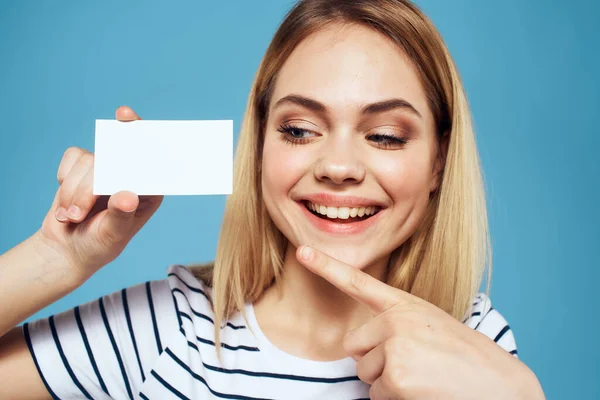 Femme avec une carte de visite dans ses mains un T-shirt rayé fond bleu Espace de copie — Photo