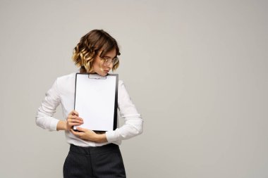Açık tişörtlü bir iş kadını ve dosyasının içinde iş görüşü kesilmiş belgeler var.