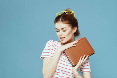Not defterleri ve sarı gözlükleriyle mavi arka plan bilim enstitüsünde güzel bir bayan öğrenci.