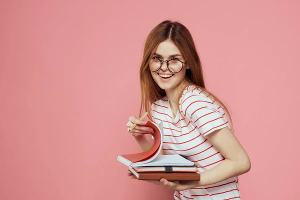 Jeune étudiante avec des livres sur les lunettes de fond roses sur le visage institut d'éducation vue recadrée — Photo