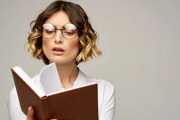 Επιχειρηματίας γυναίκα με σημειωματάριο και γυαλιά σε ένα ελαφρύ φόντο hairstyle επιτυχία συναισθήματα — Φωτογραφία Αρχείου