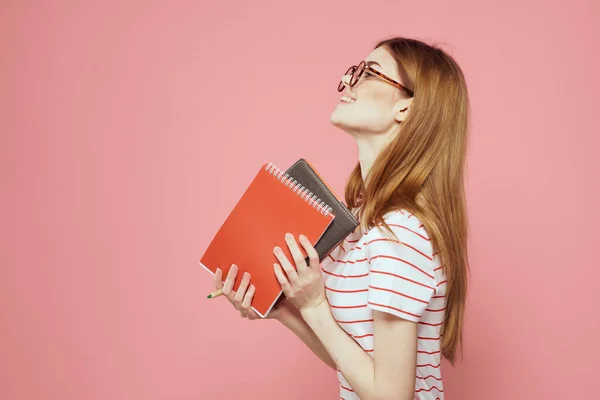 Krásná žena student držení knih vzdělávání institut gestikulace s rukama růžové pozadí kopírovat prostor — Stock fotografie