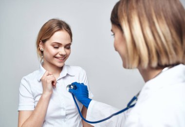 Steteskoplu bir doktor ve arka planda mutlu bir hasta.