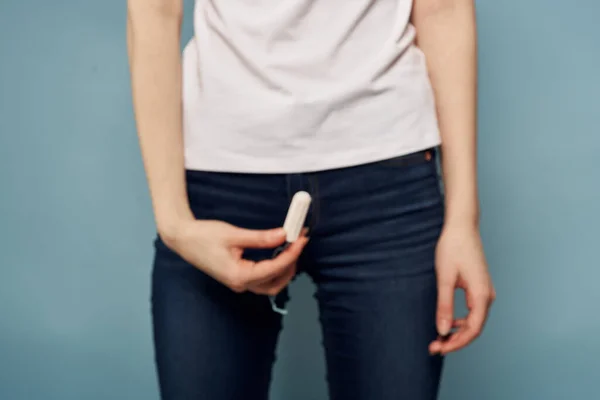 Mujer con tampón y jeans camiseta menstruación fondo azul recortado ver higiene — Foto de Stock