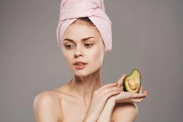 Mulher alegre vestindo toalha rosa na cabeça de saúde de abacate — Fotografia de Stock
