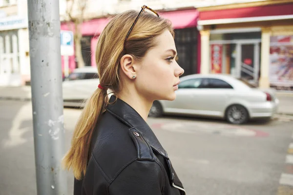 Woman at a stop on the street and parked cars in the background — Stock Photo, Image