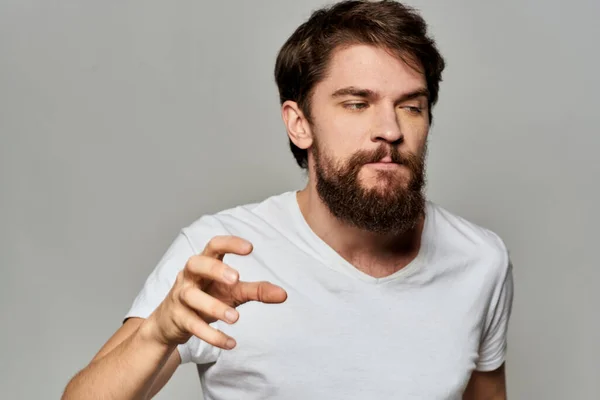 Man in wit t-shirt emoties expressies gebaar met handen bijgesneden bekijk licht achtergrond — Stockfoto