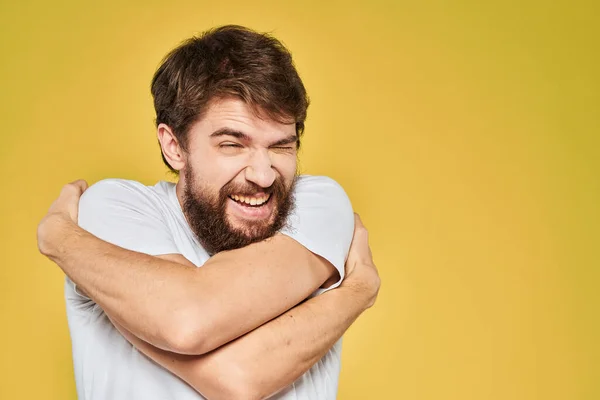 Бородатий чоловік у білій футболці емоції крупним планом весело жовтий фон — стокове фото