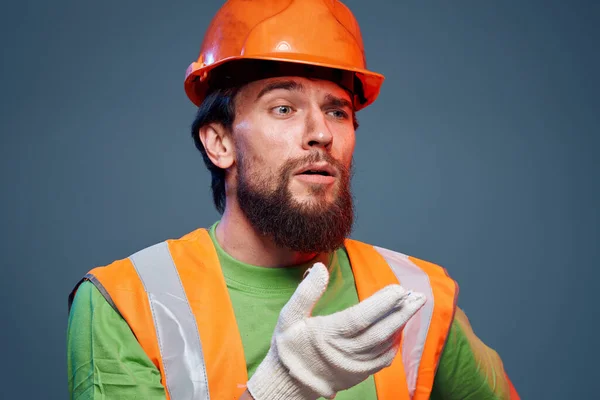 Man in work uniform orange paint safety work fatigue blue background