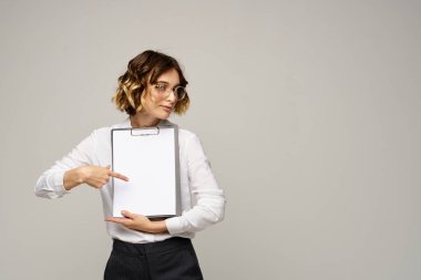 Açık tişörtlü bir iş kadını ve dosyasının içinde iş görüşü kesilmiş belgeler var.