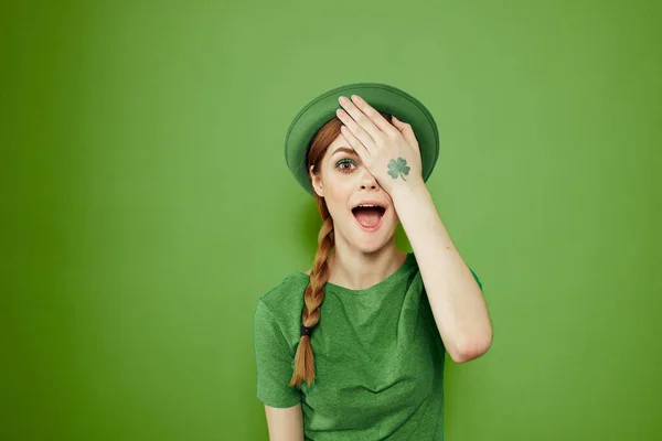 Bella ragazza con un trifoglio sulla mano su uno sfondo verde vacanze St. Patricks Day divertente cappello sulla testa — Foto Stock