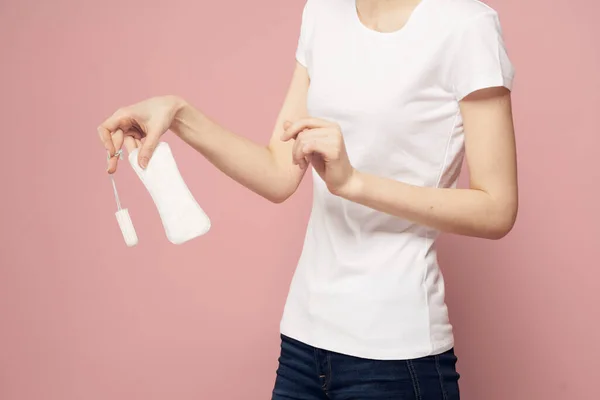 Дівчина з подушечками і тампонами в руці рожевий фон менструації критичні дні гігієна — стокове фото