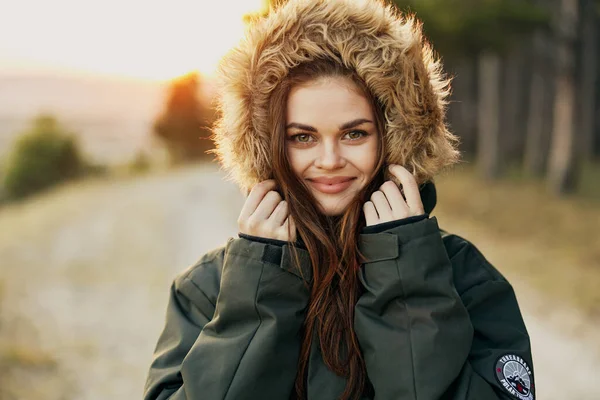 Sonriente mujer en una capucha primer plano en la naturaleza recortado vista — Foto de Stock