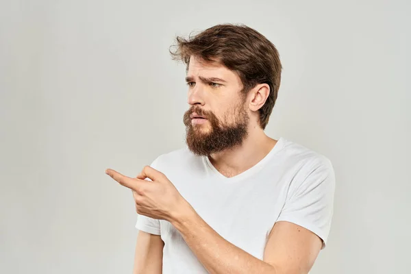 Чоловік у білій футболці жестикулює своїми руками студія невдоволення стилем життя легкий фон — стокове фото