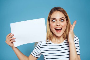 Elinde kağıt şeritli tişört tutan kadın Boşluğu kopyalanmış mavi arkaplan