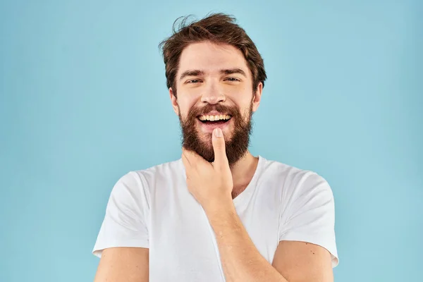 Uomo emotivo con la barba in una t-shirt bianca sfondo blu stile di vita divertente — Foto Stock