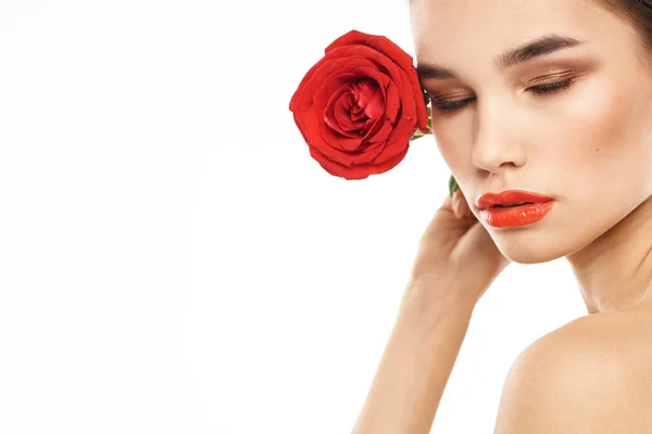 Belle femme avec rose rouge près du visage maquillage épaules nues portrait — Photo
