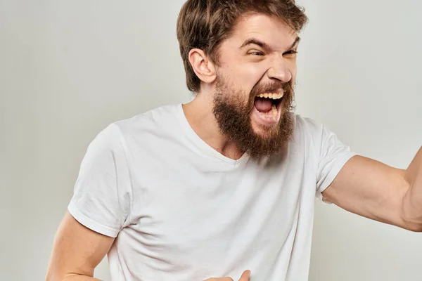 Чоловік в білій футболці емоції вирази жест з руками обрізаний вид світлого фону — стокове фото