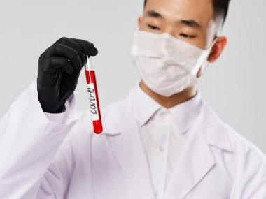 Erkek laboratuvar asistanı beyaz önlük siyah eldiven test tüpü ve kan testi.