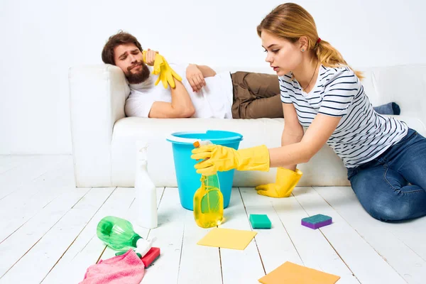 Young couple at home near sofa washing supplies cleaning lifestyle — Stock Photo, Image