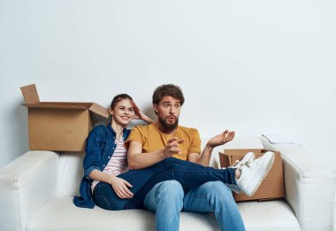 Erkek ve kadın yeni bir apartman dairesinde, içi eşyalarla dolu.