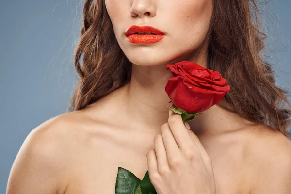 Donna con una rosa tra le mani spalle nude trucco sera labbra rosse — Foto Stock