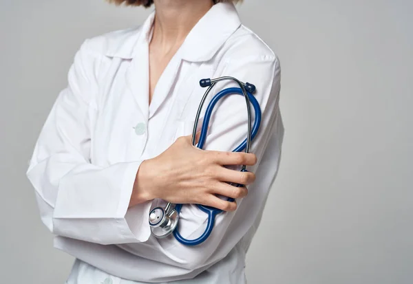 Женщина в белом халате доктор и стетоскоп в руке — стоковое фото
