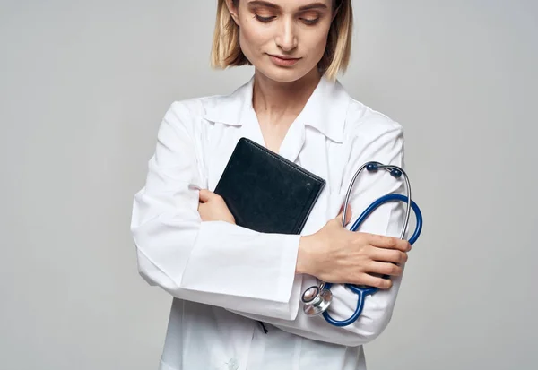 Steteskoplu kadın doktor ve hastane önlüğü belgeleri ellerinde. — Stok fotoğraf