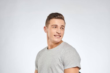 Gri tişörtlü yakışıklı adam duygu stüdyosu modelini kesmiş.