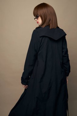 Gülümseyen kadın kıyafetleri bej bir arka planda gülüyor. 