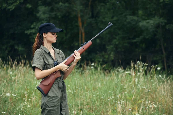 Mujer soldado Con un arma en la mano, una gorra negra está recargando monos verdes — Foto de Stock