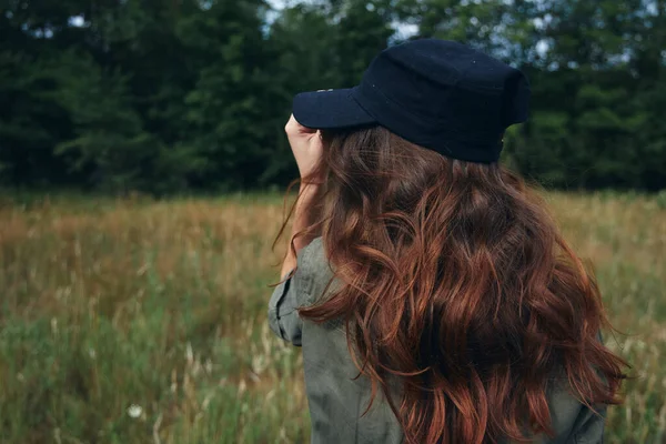 牧草地で抜け毛のある青い帽子の女性は — ストック写真
