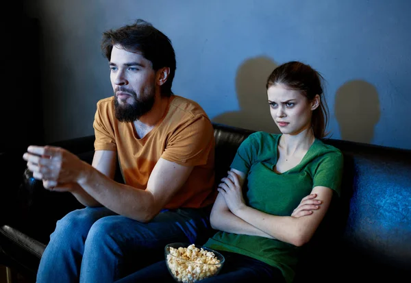 Ein Mann und eine Frau schauen sich im Kino auf dem Sofa drinnen einen Film an — Stockfoto