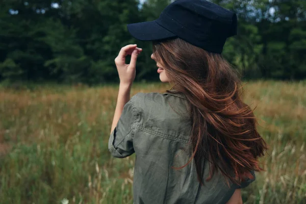 Kobieta w czapce z długimi włosami Zielona koszula natura — Zdjęcie stockowe