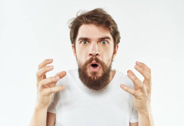 Beyaz tişörtlü genç bir adam elleriyle hareket eder. Duyguları gerilir.