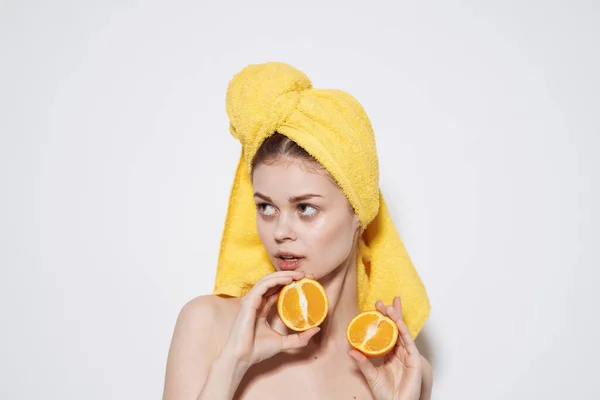 Веселая женщина с желтым полотенцем на голове обнаженные плечи апельсины в руках чистой кожи — стоковое фото