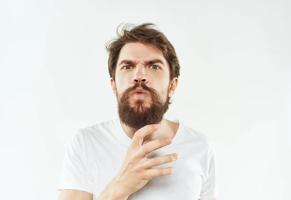 Un giovane uomo in una maglietta bianca gesti con le mani emozioni irritabilità stress — Foto Stock