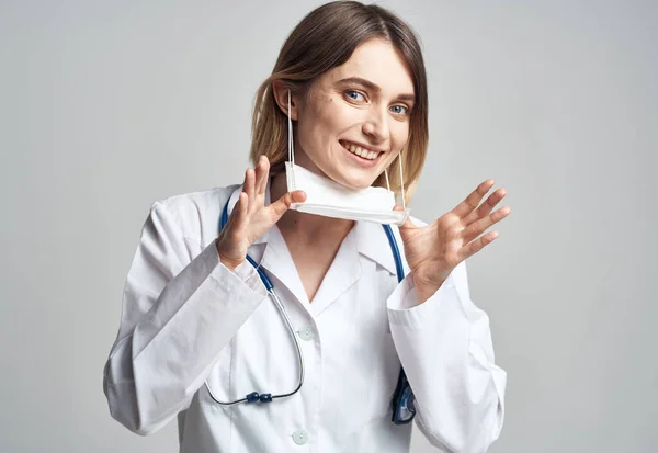 Mujer feliz médico en máscara médica con estetoscopio en el cuello —  Fotos de Stock