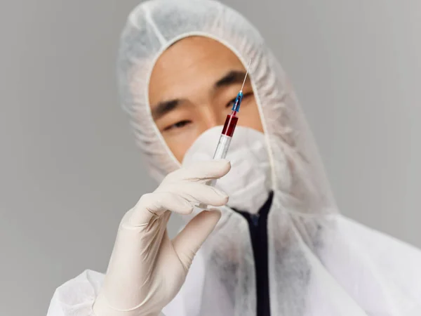 Людина в захисному медичному одязі вакцина лабораторні дослідження крупним планом — стокове фото