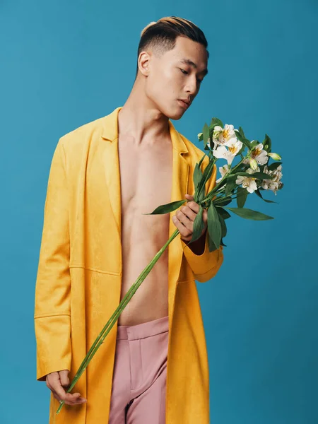 Homem romântico com um buquê de flores em um fundo azul — Fotografia de Stock